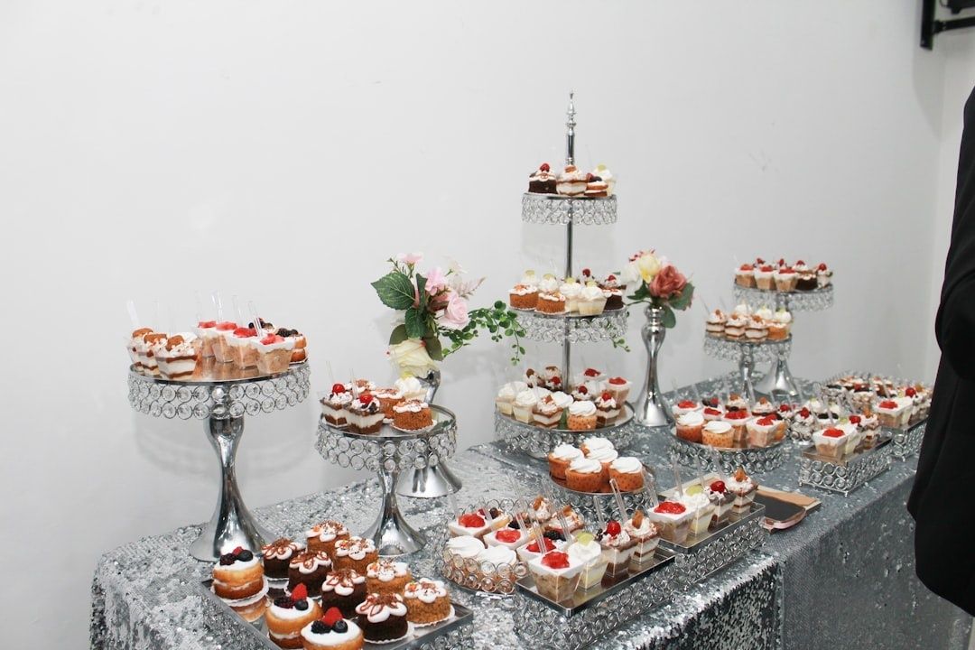 Feestelijk gedekte tafel met gebak en zoete hapjes op etagères